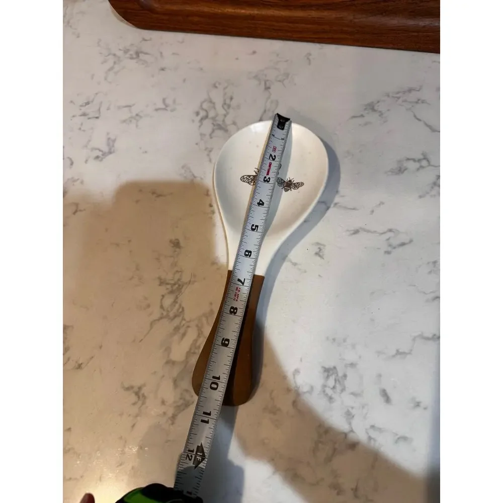 white ceramic spoon rest black bee graphic contrasting brown dipped handle